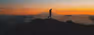 Ascending Horizons: The Path to Leadership Silhouetted against a sunrise, a lone figure strides atop a mountain, symbolizing the ascent of an emerging leader toward self-discovery.