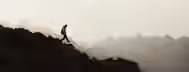 Ascending to Leadership: A Journey of Growth A lone hiker ascends a rugged mountain at dawn, symbolizing the challenging journey of personal growth and self-discovery.