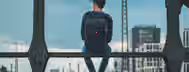 Reflecting on the Path to Personal Growth A young individual with a backpack sits on a bridge, gazing thoughtfully into a cityscape, embodying the journey of an emerging leader.