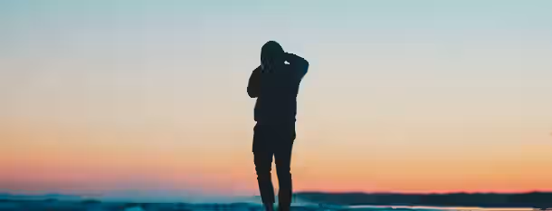 Embracing the Horizon of Self-Discovery Silhouette of a person gazing at the horizon, symbolizing a leader's journey to endless possibilities and self-improvement.
