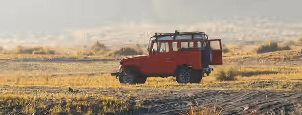 Trailblazing the Path to Leadership A red jeep with open doors atop a sunlit field, symbolizing an emerging leader’s adventurous journey towards self-improvement.
