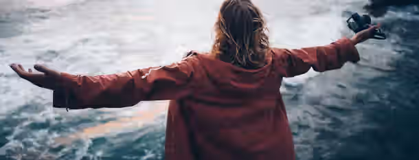 Embracing Horizons: The Journey to Leadership Standing at the edge of the ocean, arms wide open, embracing endless possibilities and personal growth.