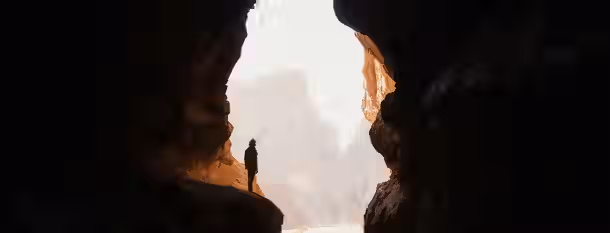 Emerging from Shadows: A Leader's Inner Journey A solitary figure emerges from a dark cave, symbolizing the journey of a leader stepping into the light of self-discovery and growth.