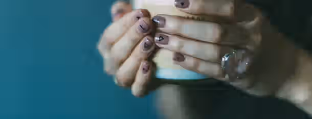Embracing Change: The Path of Emerging Leadership Hands with symbolic nail art grasp a candle, embodying the emerging leader’s journey of enlightenment and self-discovery.