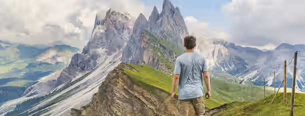 Ascending the Peak of Leadership A man stands at the base of towering mountains, contemplating his ascent, symbolizing the challenging yet rewarding journey of self-improvement.