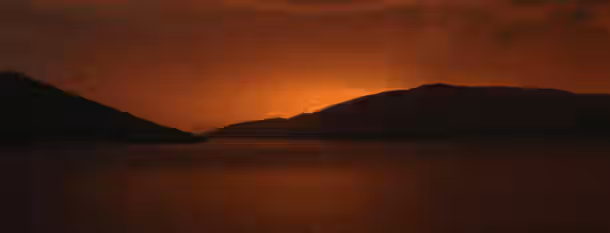 Sunset over the Path of Growth A tranquil sunrise over still waters, symbolizing an emerging leader finding clarity and purpose on their path to self-improvement.