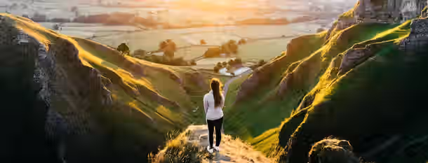 Ascend to New Horizons: A Leader’s Path to Growth A lone figure stands on a sunlit peak, overlooking a vast and promising valley, symbolizing a leader's journey toward self-discovery.