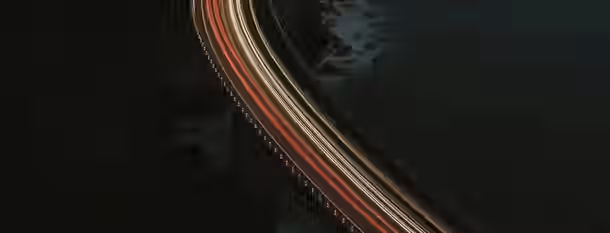 Navigating the Path to Leadership Excellence A winding path illuminated by headlights symbolizes the evolving journey of an emerging leader's self-improvement and growth.