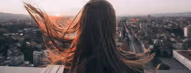 Rise Above: A Leader's Vision at Dawn Standing high above the city at sunset, she gazes into the horizon, embracing the journey toward self-discovery and leadership.