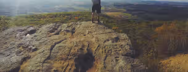 Ascending Peaks: A Leader's Journey to Growth Standing on a rugged cliff edge, an individual gazes over vast, scenic valleys, symbolizing the horizons of their leadership growth.