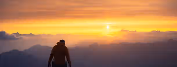 Rising Above: The Dawn of Leadership A climber stands at dawn, symbolizing the emerging leader overcoming obstacles and embracing new beginnings on their path to growth.