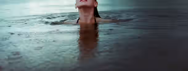 Emerging from the Depths: A Leader's Self-Discovery Rising above the water, a figure gazes upward, symbolizing the journey of self-improvement and emerging leadership.