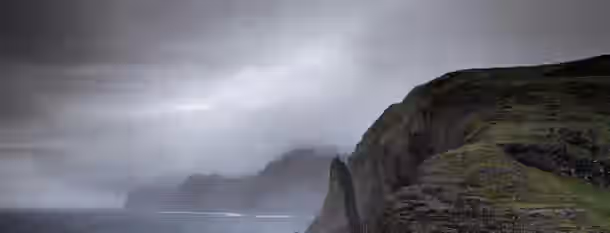 Climbing the Fog of Self-Discovery Misty cliffs rise from the ocean, symbolizing the emerging leader's journey to self-improvement and overcoming challenges.