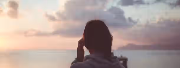 Embracing the Dawn of Leadership A person stands at the edge of a calm sea during sunrise, symbolizing the dawn of a new journey of self-discovery and leadership.