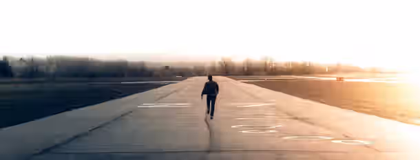 Pathway to Leadership: A Journey Begins Walking into the sunrise, a solitary figure symbolizes the journey of an emerging leader towards self-improvement and discovery.
