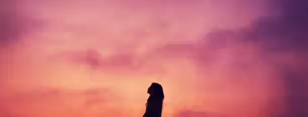 Silhouette at Dawn: Path to Self-Discovery A silhouette gazes upward against a vibrant sunset, symbolizing the journey of an emerging leader seeking growth and enlightenment.