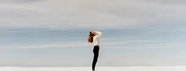 Reaching for New Horizons Standing alone in a vast, serene landscape beneath a wide sky, she symbolizes the journey of an emerging leader finding direction.