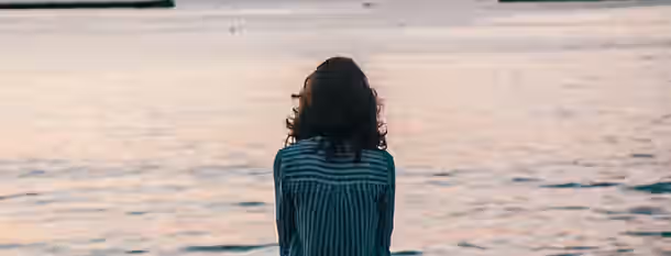 Reflecting by the Water: A Leader's Journey Begins Contemplating horizons, a young leader gazes at the tranquil water, ready to embark on a journey of growth and self-discovery.