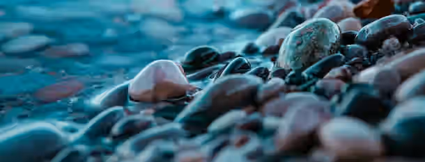 Polished Stones: Journey to Leadership Smooth stones shaped by water, symbolizing an emerging leader’s journey through challenges and self-improvement.