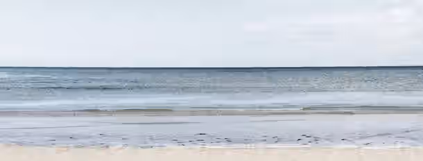 Horizons of Self-Discovery Calm ocean waves gently lap against a sunlit shore, symbolizing the steady and peaceful journey of an emerging leader's self-improvement.